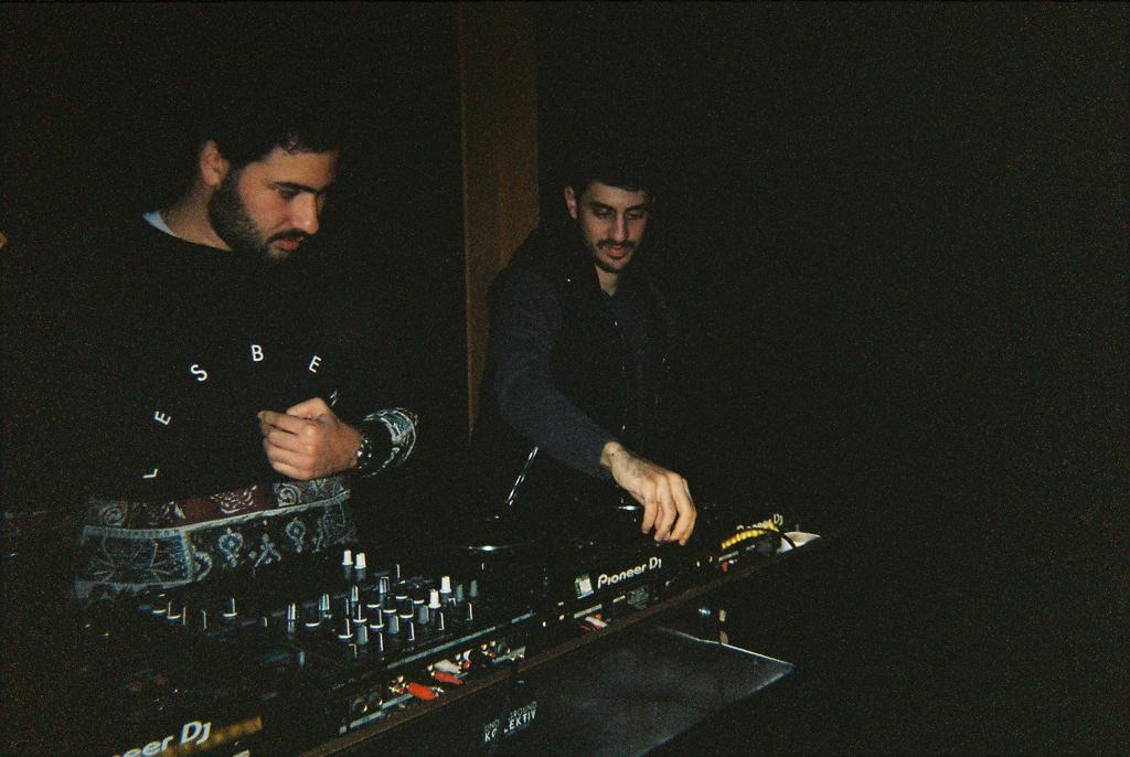 Two DJs behind the decks at a party