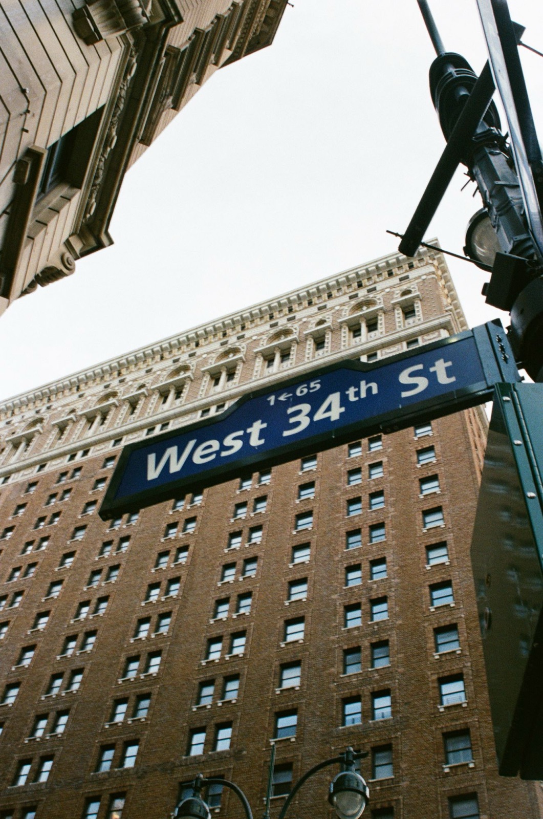 A West 34th Street sign against a brick tower, on film